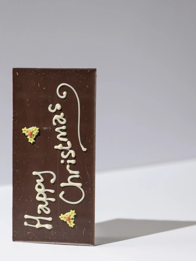 A dark, Milk or white chocolate solid bar with a hand piped Happy Christmas message and edible stars