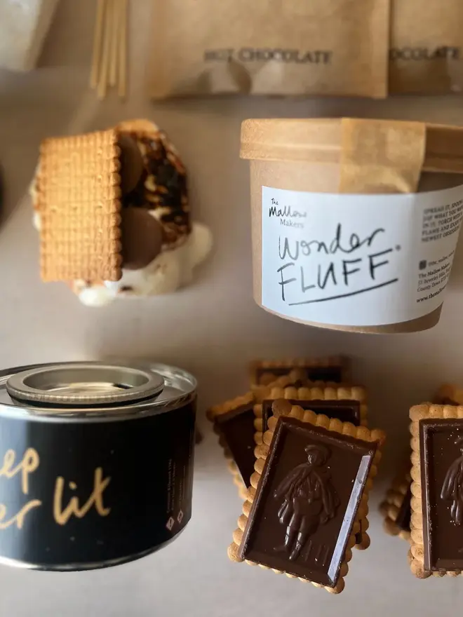 Luxury S'mores & Hot Chocolate Kit, the kit laid out on a marble surface. Pictured is the biscuits, burner, melters and fluff. 