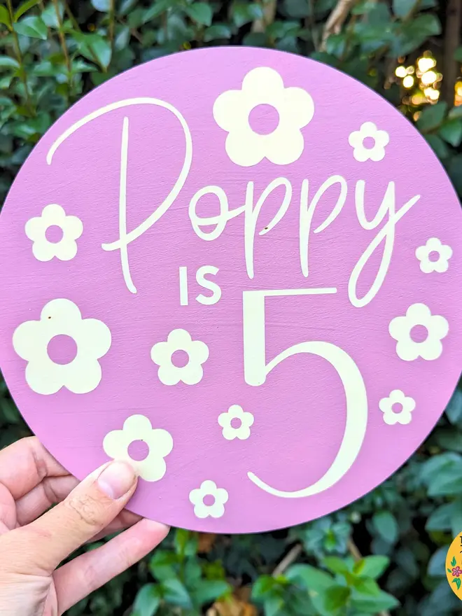 personalised wooden birthday sign. a purple round wooden sign with a personalised birthday message.