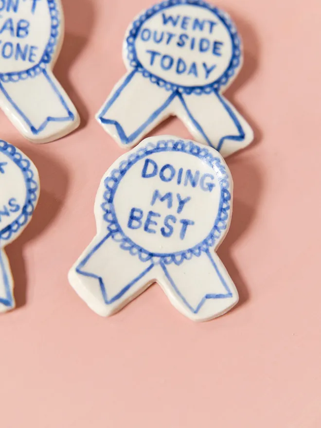  Blue Handmade Ceramic Award, a group of blue and white ceramic award badges sitting on a ink surface. 