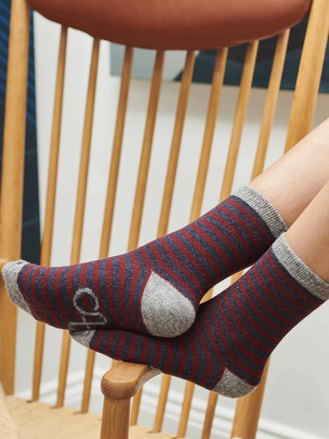 Women's Organic Cotten Striped Ankle Socks, a woman resting her feet, wearing a pair of striped ankle socks. 