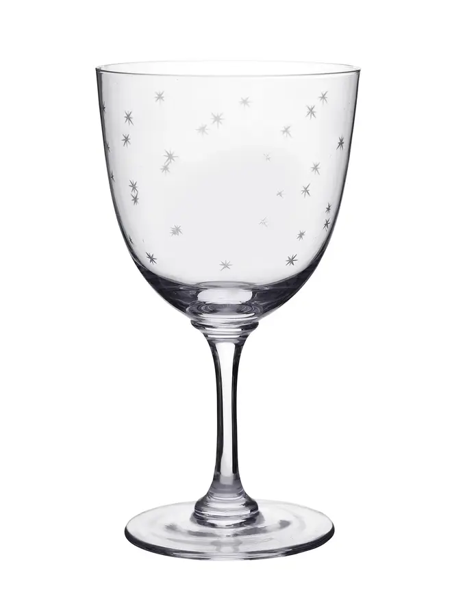 engraved stars crystal wine glass. a crystal wine glass with star details.