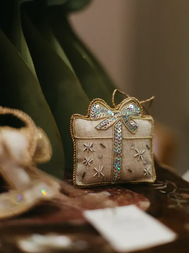 embroidered linen present decoration. christmas gift hanging ornament photographed on dark wooden shelf.