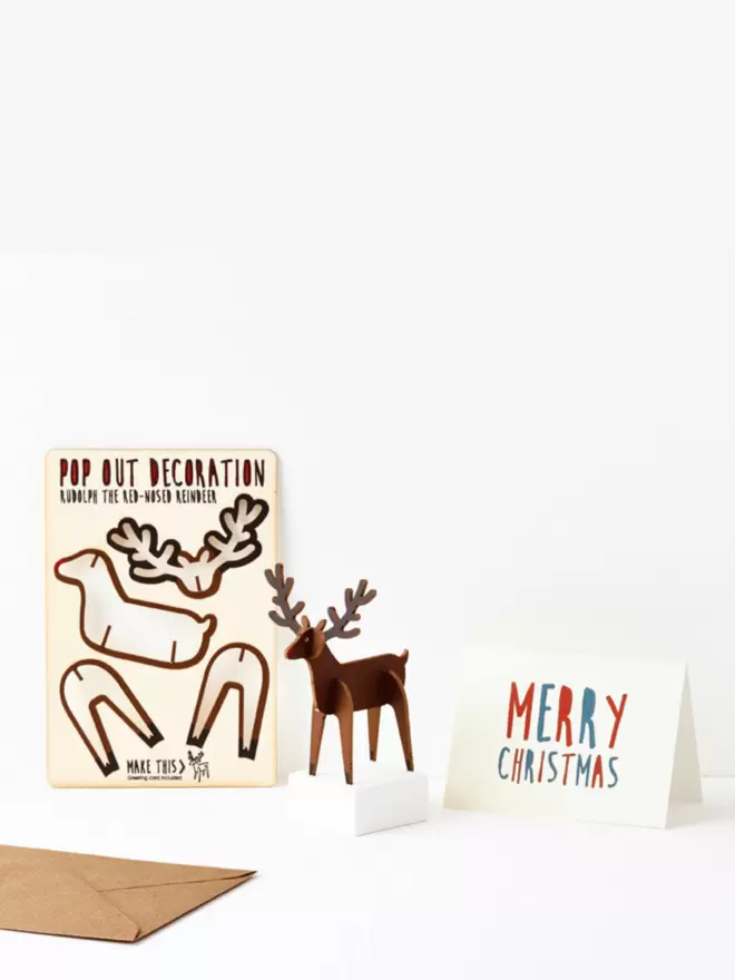 Pop out Rudolph Christmas decoration and Merry Christmas card and brown kraft envelope on a white background