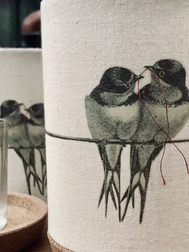 two birds with thread joining their beaks