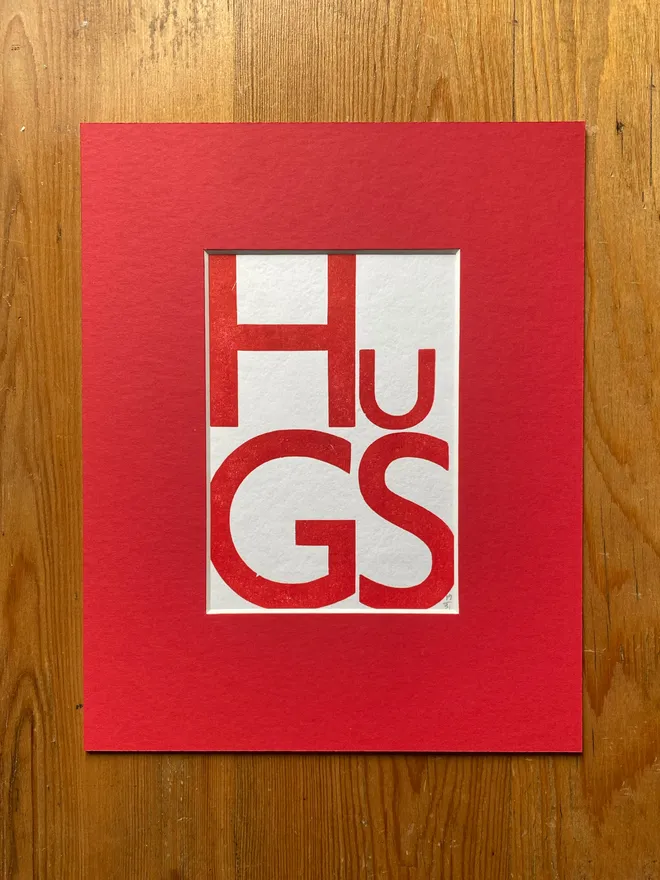 HUGS poster in red mount