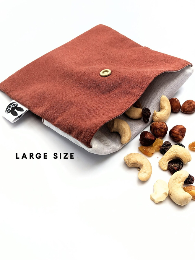 reusable linen snack pouch. a rust brown pouch holding trailmix.