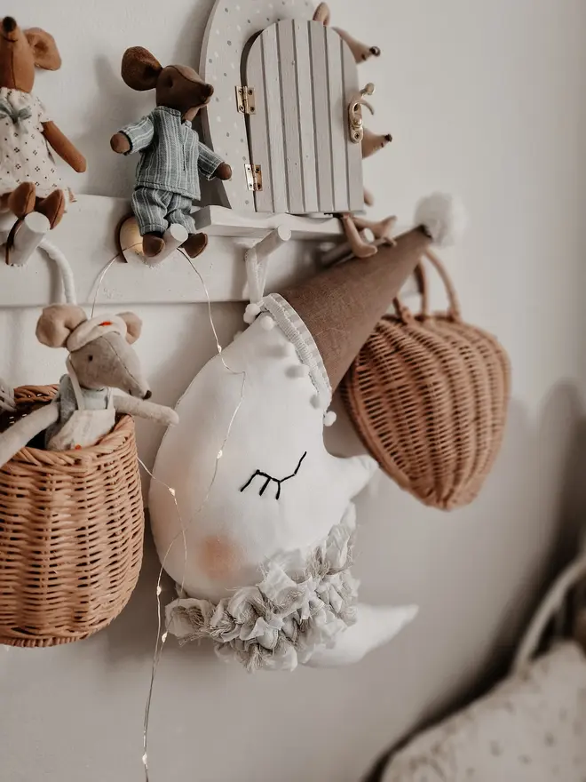 Hanging Moon Pillow Decoration, a hanging moon pillow decoration suspended from a shelf amongst other bedroom decoration items. 