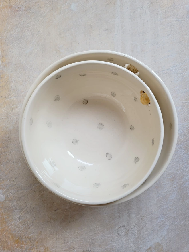 flat lay aerial view of a grey and white spotty dotty bowl stacked inside a larger bowl