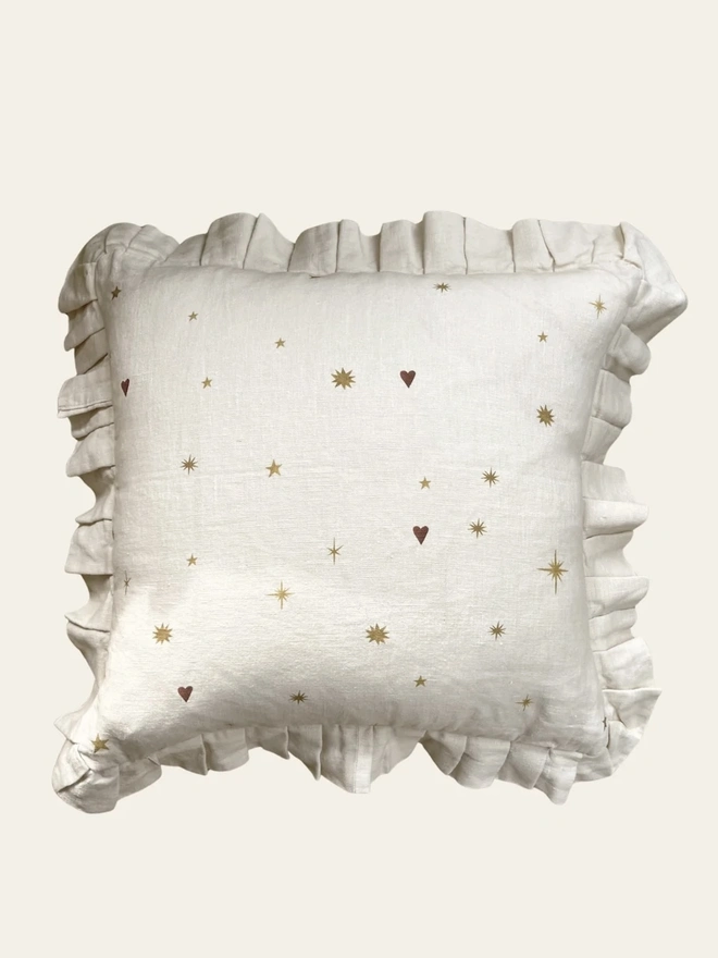 'Love Sun' Linen Ruffled Cushion Cover, a linen cushion with a sun and cloud motif on it sitting on a plain surface.