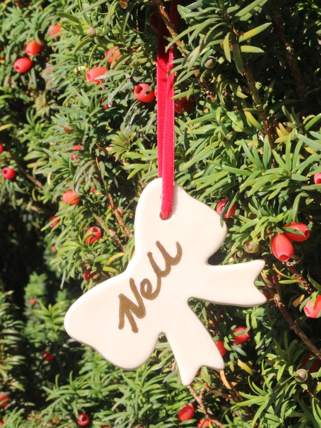 red velvet ribbon ceramic bow handmade and finished with hand painted personalised name in gold lustre