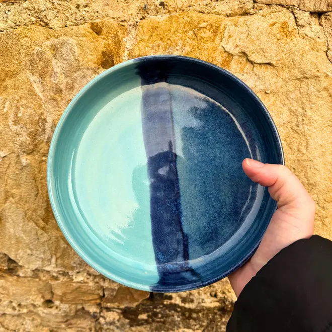 Landscape Pasta Bowl, a colourful pasta bowl held against a brick backdrop. 