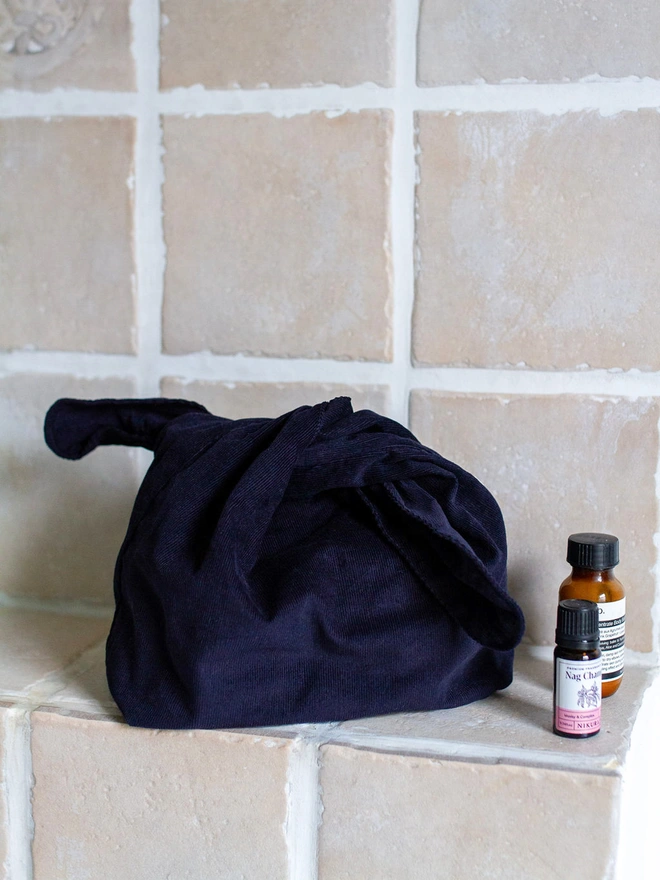 navy blue make up bag on bathroom shelf 