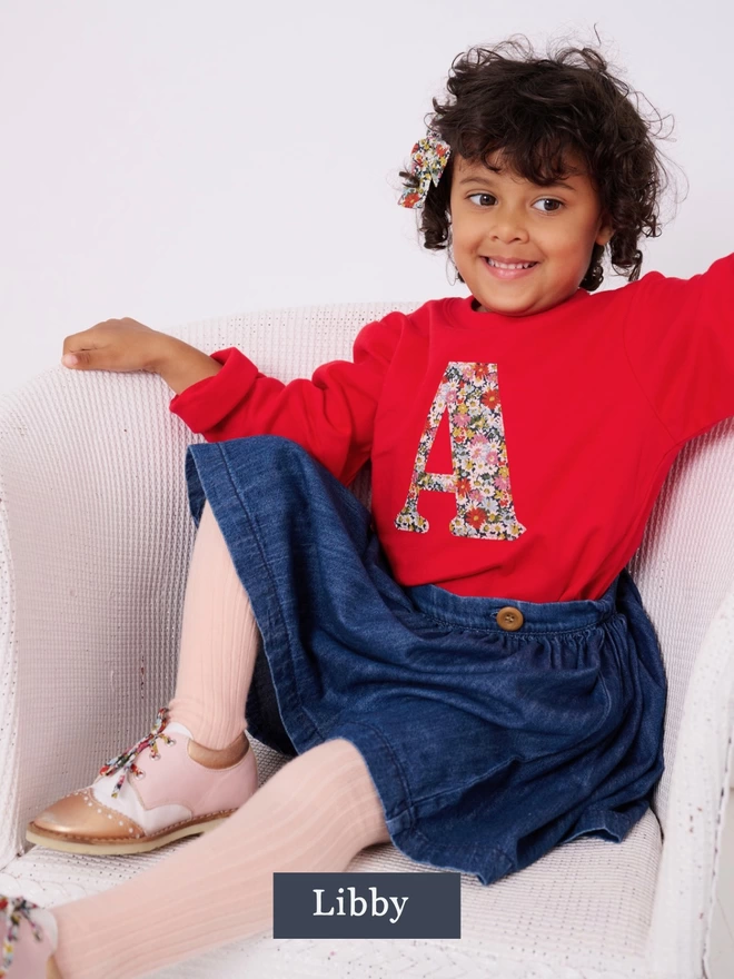 Liberty print Letter A red tee in Libby floral print. Worn by a smiling 4 year old girl.