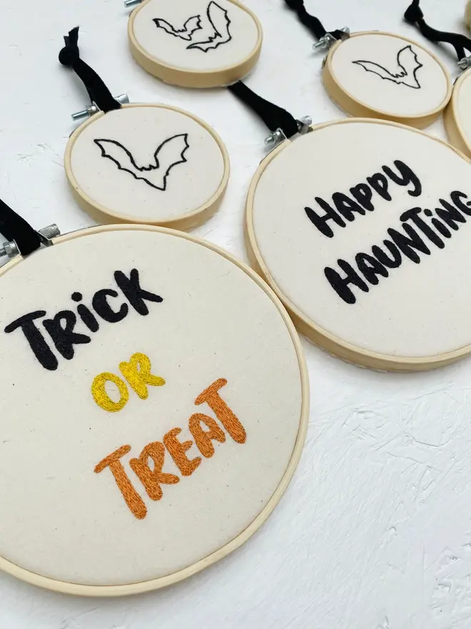 spooky phrase embroidered hoop. embroidered halloween hoops photographed with decorations.