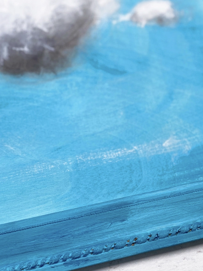 large cloud painting in turquoise painted directly onto a frame