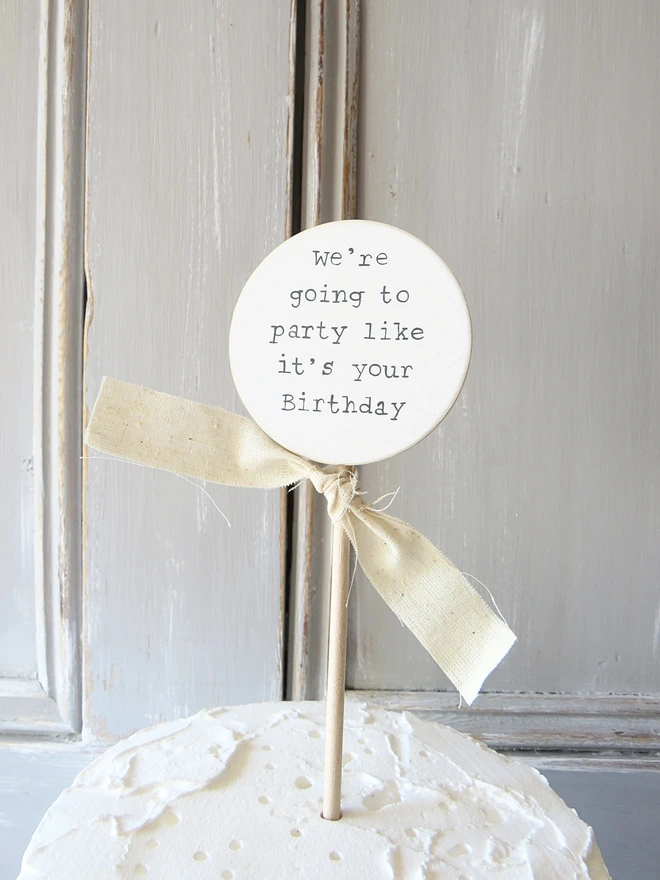 wooden circle shaped cake topper with hand painted message and custom ribbon