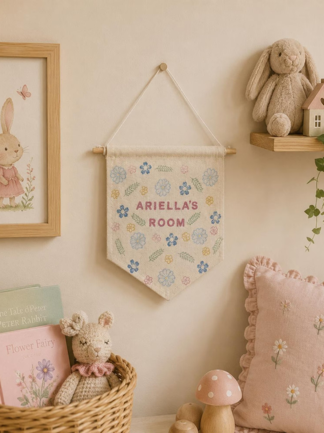 customised kids' bedroom cotton wall hanging. a banner with printed flowers hanging on a bedroom wall.