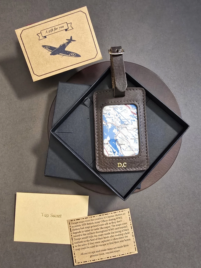 natthakur brown leather luggage tag featuring an original silk war escape map with a spitfire gift card and a card explaining information about the silk maps