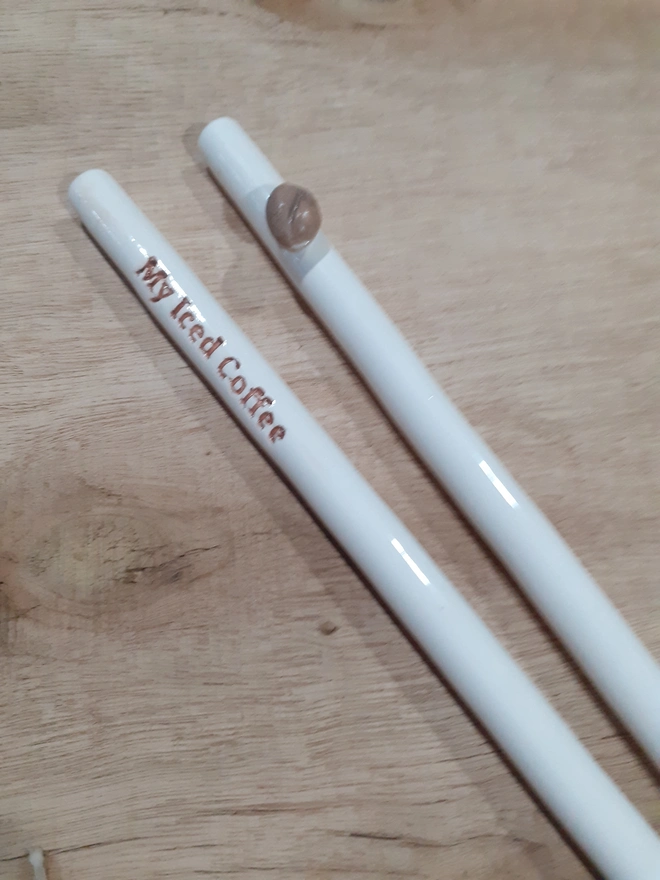 Eco-friendly handmade ceramic straw for iced coffee, reusable and dishwasher safe with lettering and raised coffee bean design