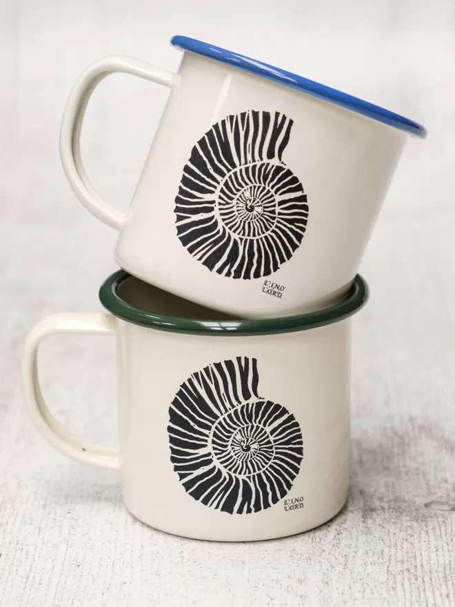 Picture of 2 Cream Enamel Mugs with a Ammonite design etched onto it, taken from an original Lino Print