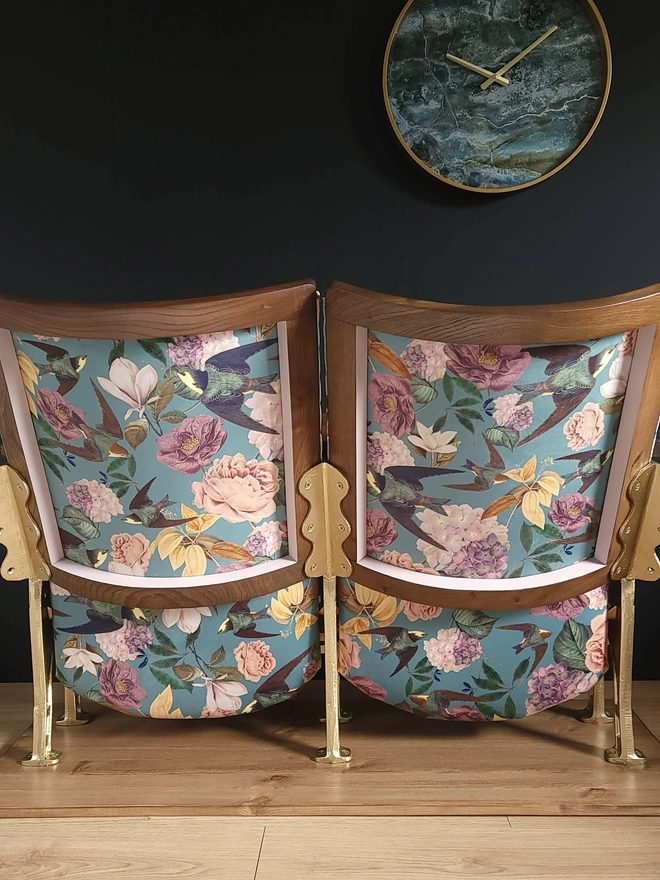 Back of a set of two vintage cinema seats with floral velvet panels