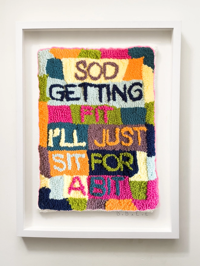 'Sod Getting Fit' Small Textile Art, a framed artwork sitting on a wall. 