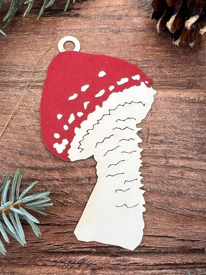 Christmas Mushroom Ornament with dark red pointed cap and white stalk.  Ornament is threaded with thin gold hanging loop.