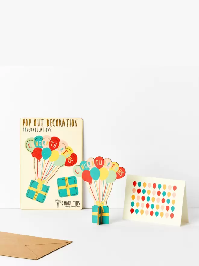 Pop out congratulations decoration and balloon pattern card and brown kraft envelope on a white background