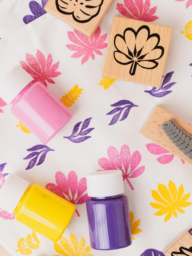 violet, pink and yellow paint on a tea towel and stamps