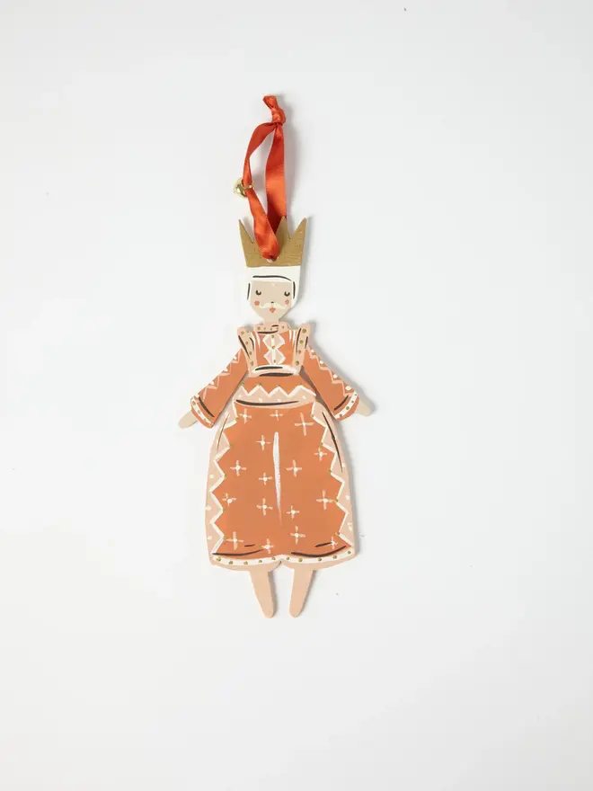 Prince Tree Dancer. wooden hanging prince decoration with a gold crown, terracotta robe with white star and diamond patterning, orange ribbon with a jingle bell, on a white background