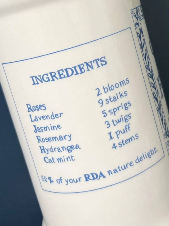 A close-up of the blue illustrated jar label which wraps around handmade Garden Flowers vase.