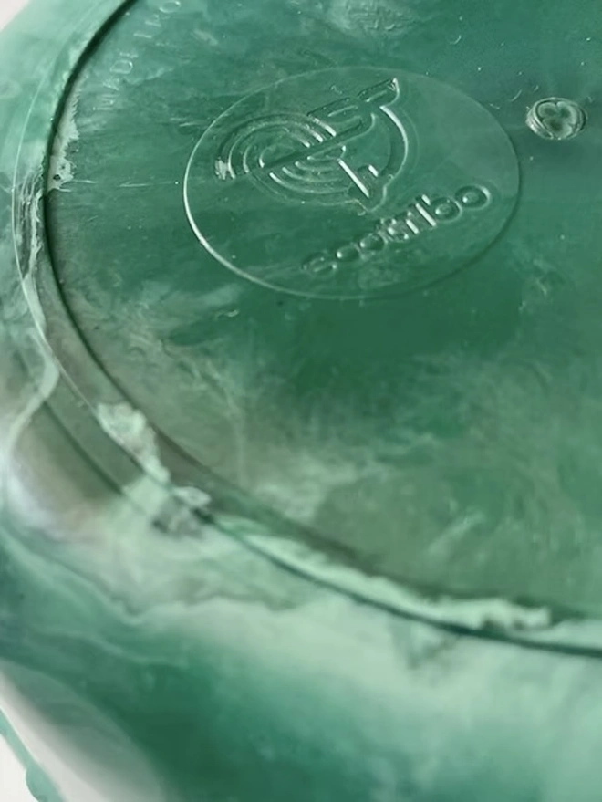 Ocean Plastic Plant Pot Small, a green recycled plant pot sitting on a white surface against a plain backdrop. 