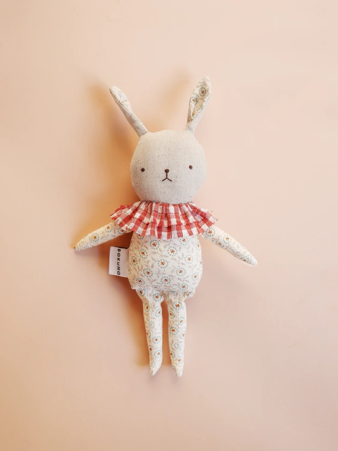 natural linen rabbit doll with printed floral outfit and ruffled gingham lace collar with embroidered gentle face feature.