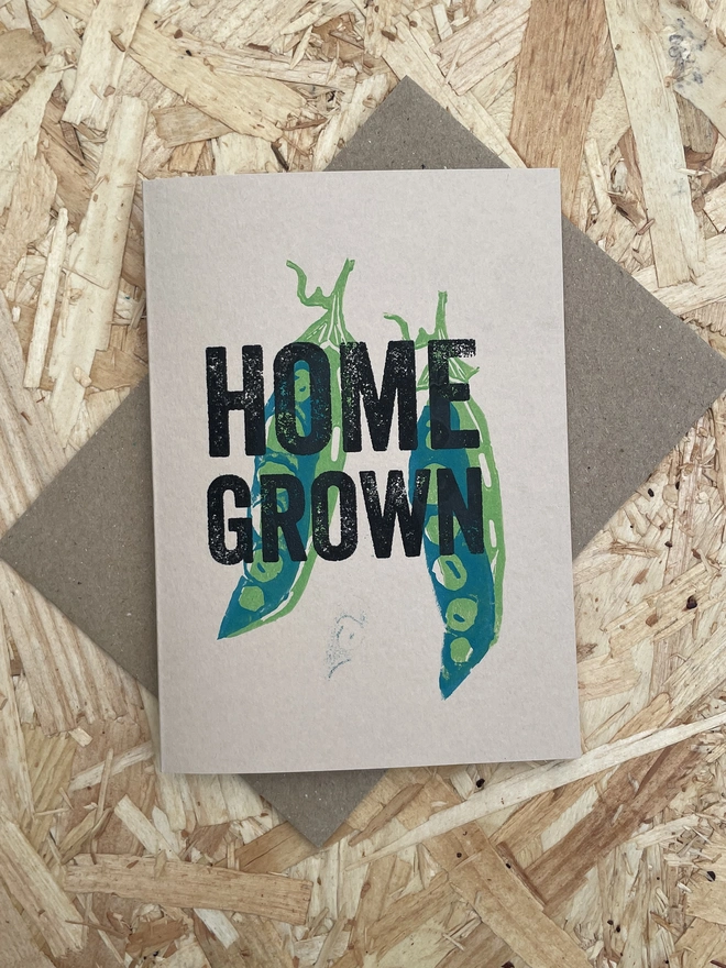 'Home Grown' Pea Lino Garden Print. A display of handmade pea themed cards arranged on a wooden table. 