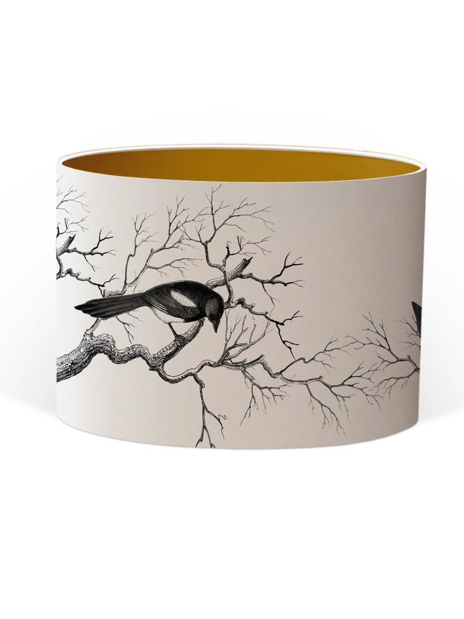 Handmade lampshade featuring cheeky magpies with gleaming gold details, inspired by traditional folklore and whimsical home decor.