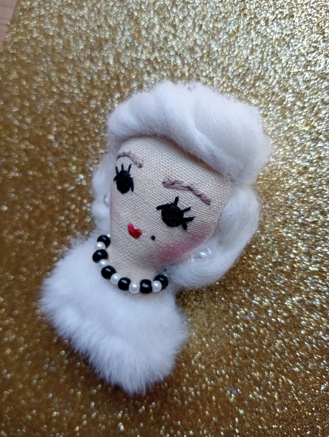 Marilyn Monroe in white fur with black and white pearl choker and crystal earrings, hanging decoration 