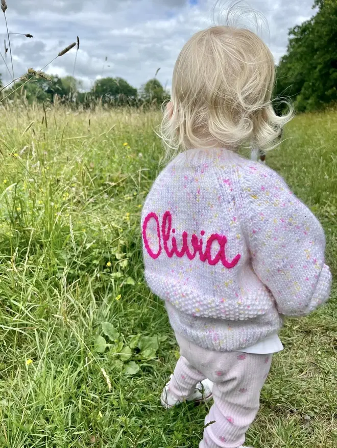 Personalised Cardigans , a young girl walking outside wearing a personalised cardigan. 