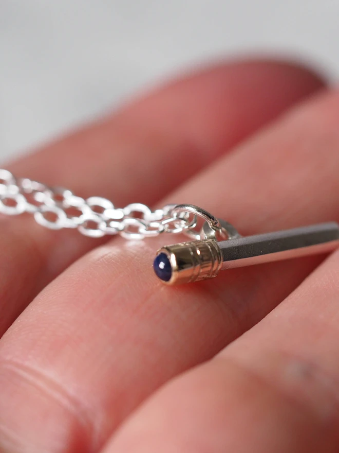 Sapphire dinky pencil charm on a hand