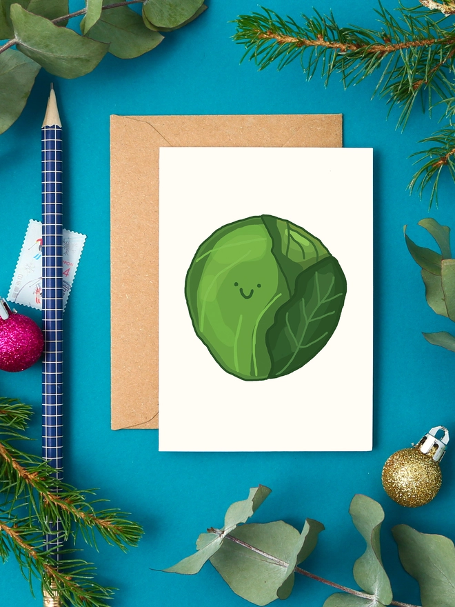 Cute mini Christmas card featuring a green Brussels sprout illustration with a smiley face