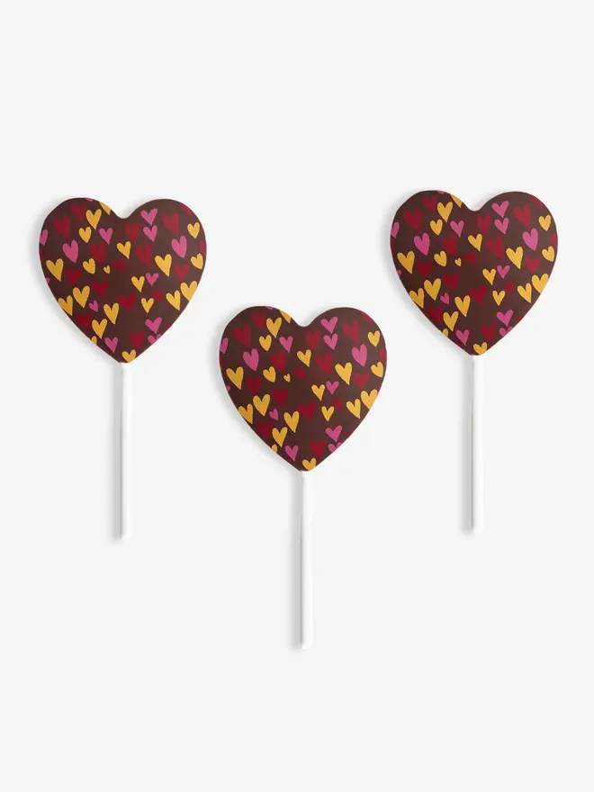 Three milk chocolate heart-shaped lollipops with Valentine's Day designs