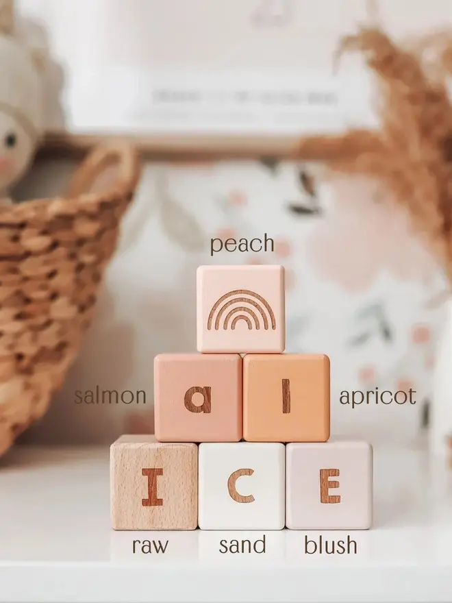 wooden baby letter blocks. a selection of square wooden blocks with engraved letters and illustrations, in various colours. 