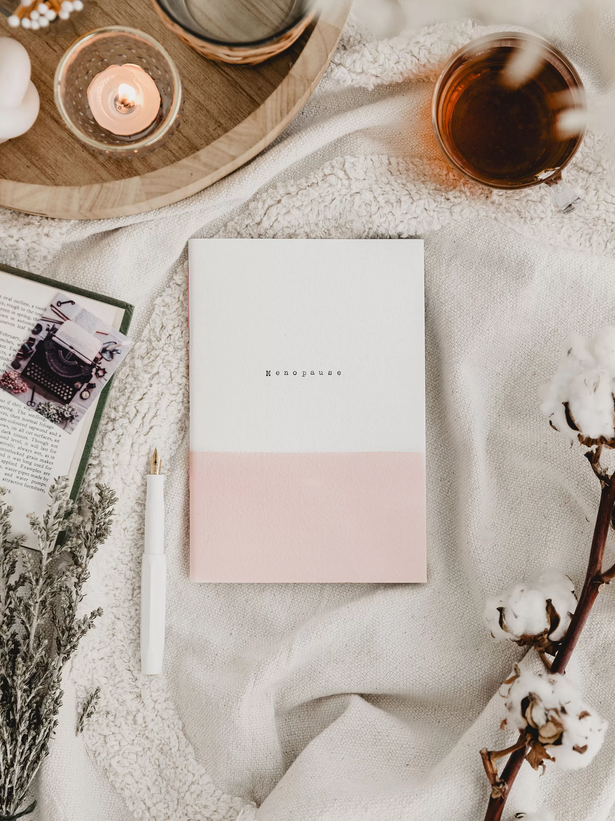 pink and white journal with 'menopause' typed on the cover
