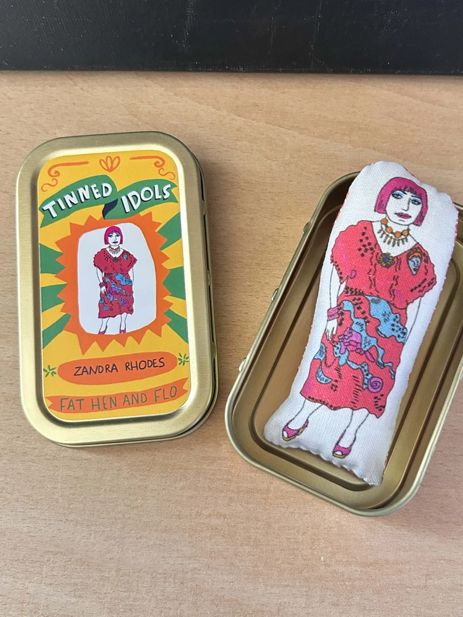 Mini illustrated fabric doll of British fashion and textile designer Zandra Rhodes in a keepsake tin.