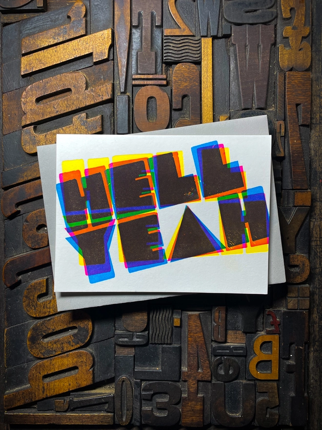 A congratulatory letterpress card using vibrant fluorescent inks the deep impression word HELL YEAH; in bold letters with a set of colourful envelopes. Perfect for exam results and graduations and other celebrations and milestones.