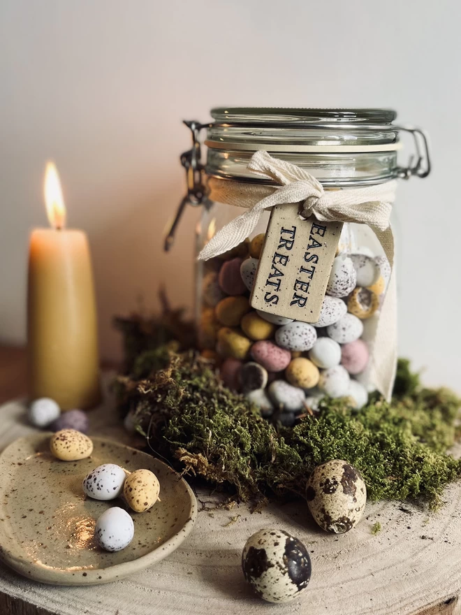 jar of mini eggs with a ceramic Easter treats tag tied around the neck