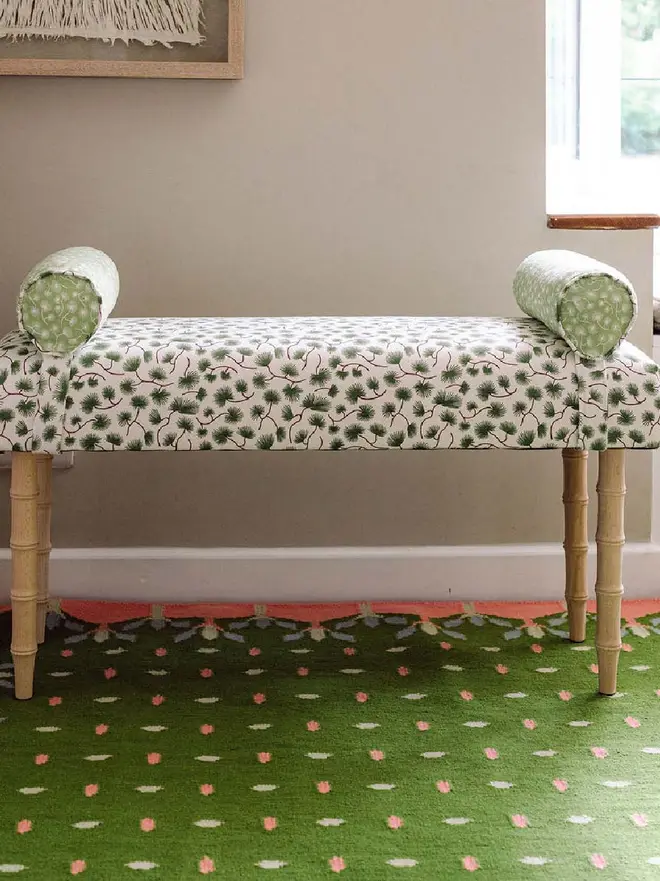 Hedgerow Flatweave Rug, a colourful rug sitting in a decorated room. It is accompanied by some household items.