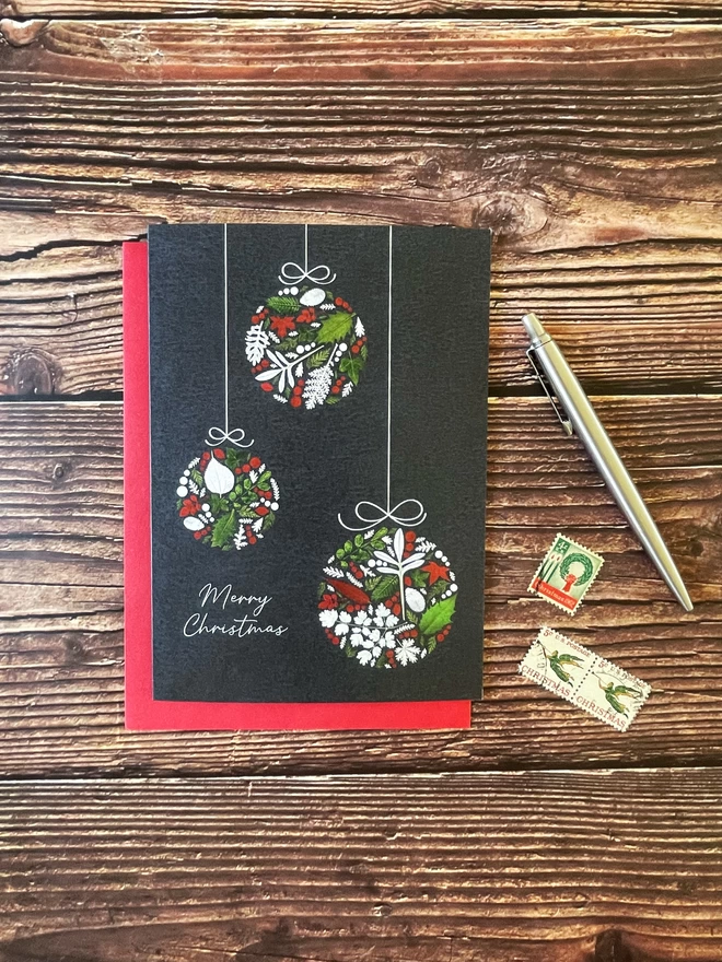 Christmas Card with 3 Bauble Design on Red Envelope - Wooden Background, Vintage Stamps and Silver Pen