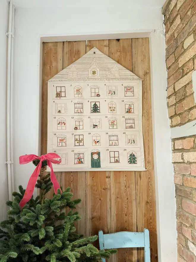 Fabric Christmas House Advent Calendar, hanging on a door. 