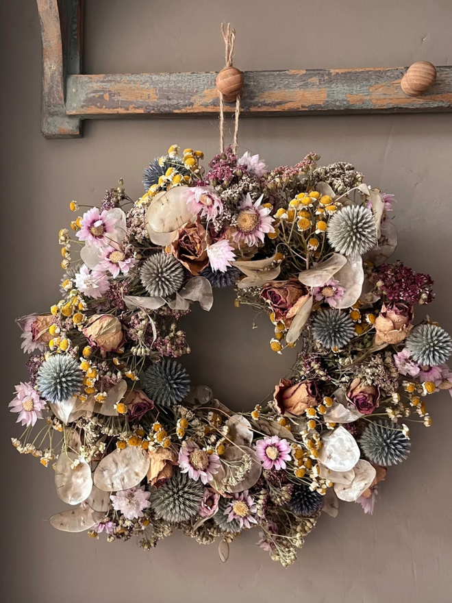 Autumnal Dried Flower Wreath. A wreath made of seasonal autumnal flowers, hung on a wall.